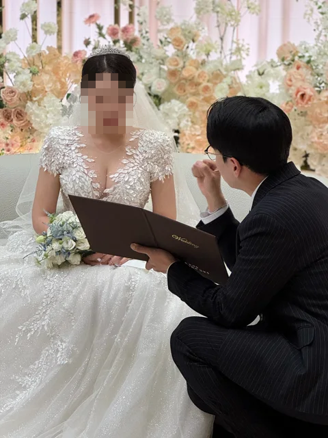 신부님과 함께 예식 자료를 살펴보는 김민울 사회자