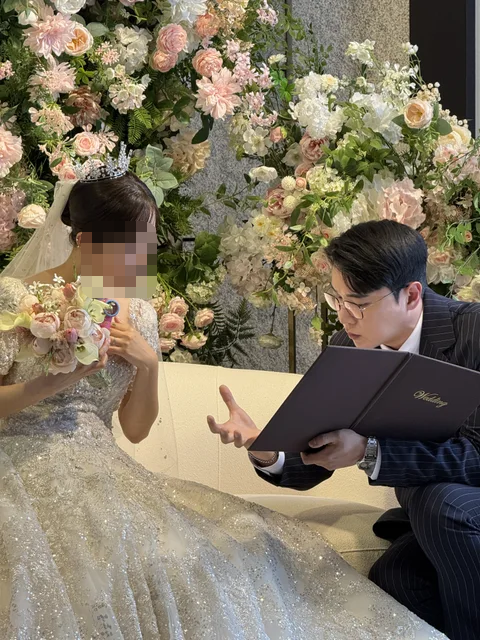 신부님과 예식 자료를 보며 대화하는 김민울 사회자